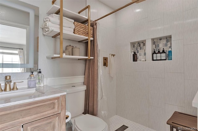 10042 Hudson St, Thornton, CO 80229 - bathroom featuring tiled shower, toilet, and vanity