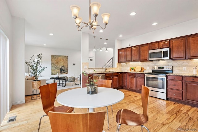 4190 W Alameda Ave, Denver, CO 80219 - kitchen with stainless steel appliances, backsplash, light wood finished floors, and recessed lighting