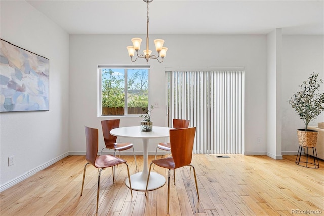 4190 W Alameda Ave, Denver, CO 80219 - dining area featuring a chandelier, wood finished floors, and baseboards
