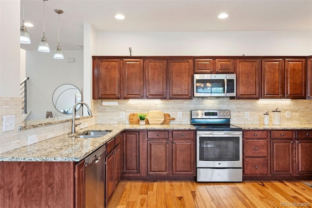 4190 W Alameda Ave, Denver, CO 80219 - kitchen featuring appliances with stainless steel finishes, a sink, light wood-style flooring, light stone counters, and decorative backsplash