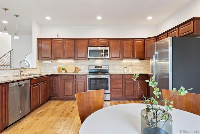 4190 W Alameda Ave, Denver, CO 80219 - kitchen with appliances with stainless steel finishes, a sink, light wood-style floors, backsplash, and recessed lighting