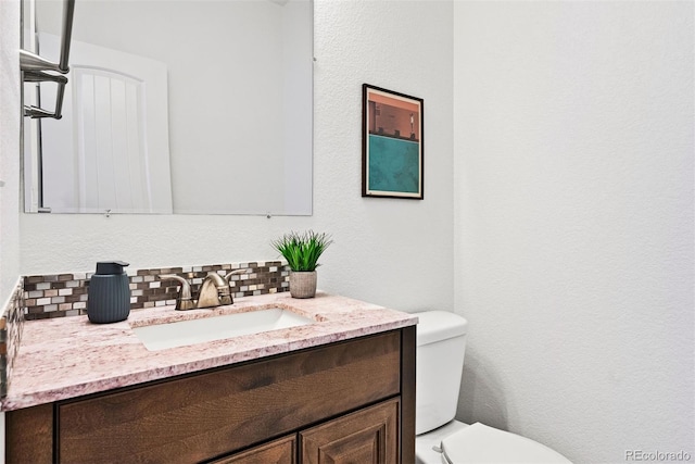 4190 W Alameda Ave, Denver, CO 80219 - bathroom featuring tasteful backsplash, toilet, vanity, and a textured wall