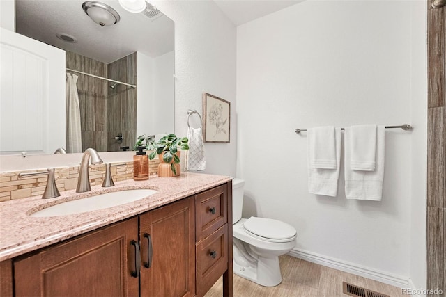 4190 W Alameda Ave, Denver, CO 80219 - full bath with toilet, a shower with shower curtain, baseboards, vanity, and wood finished floors