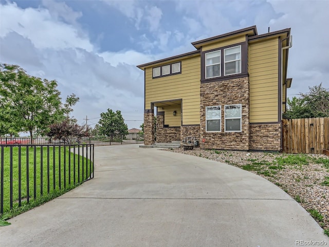 4190 W Alameda Ave, Denver, CO 80219 - view of front of home featuring stone siding and concrete driveway