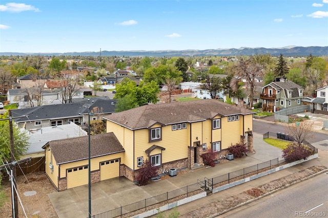 4190 W Alameda Ave, Denver, CO 80219 - view of front facade featuring a residential view, a garage, stone siding, and a fenced backyard