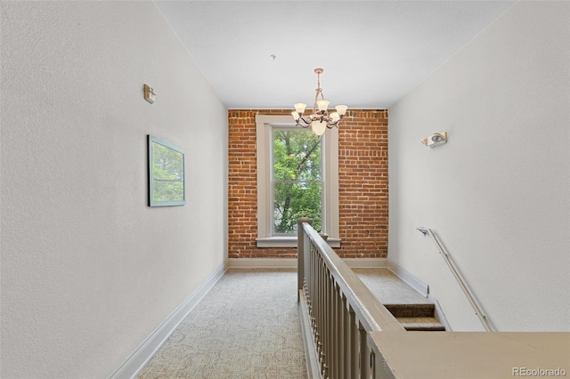 3211 Zuni St Unit 9, Denver, CO 80211 - corridor featuring a chandelier, light colored carpet, and brick wall
