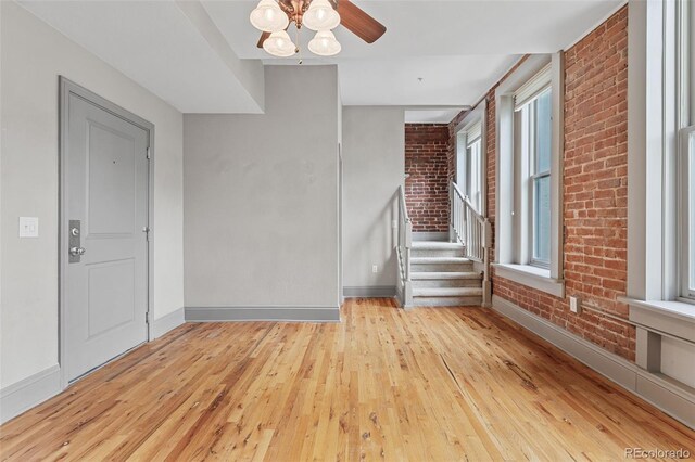 3211 Zuni St Unit 9, Denver, CO 80211 - empty room with hardwood / wood-style floors, brick wall, and stairs
