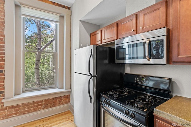 3211 Zuni St Unit 9, Denver, CO 80211 - kitchen with stainless steel appliances, light wood-style floors, and brown cabinetry