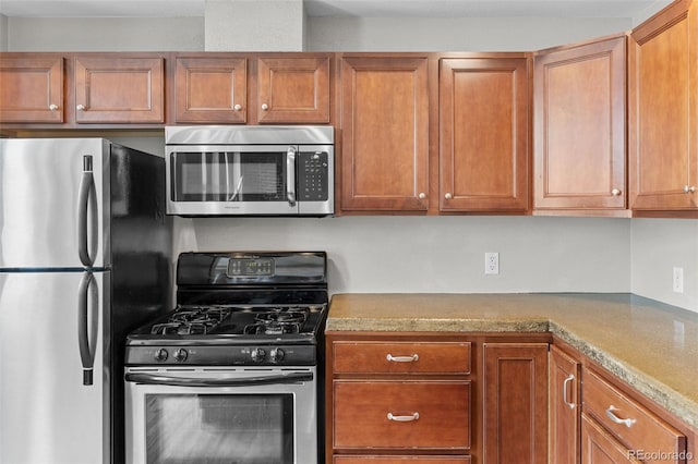 3211 Zuni St Unit 9, Denver, CO 80211 - kitchen featuring appliances with stainless steel finishes and brown cabinets