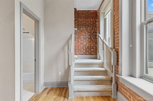 3211 Zuni St Unit 9, Denver, CO 80211 - staircase featuring brick wall and wood finished floors