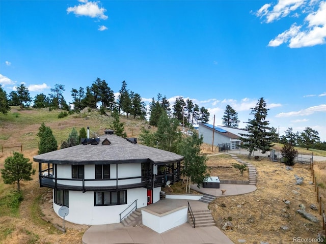 5607 Crawford Gulch Rd, Golden, CO 80403 - view of front of house with a balcony, stairs, a patio area, and stucco siding