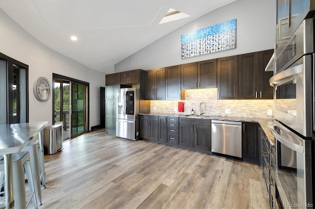 5607 Crawford Gulch Rd, Golden, CO 80403 - kitchen featuring stainless steel appliances, dark brown cabinetry, decorative backsplash, light stone counters, and recessed lighting