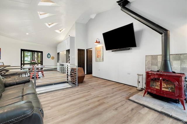 5607 Crawford Gulch Rd, Golden, CO 80403 - living room with light wood finished floors, a wood stove, a skylight, and high vaulted ceiling
