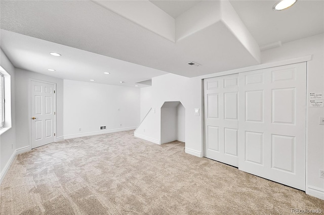 basement featuring carpet flooring, recessed lighting, baseboards, and arched walkways