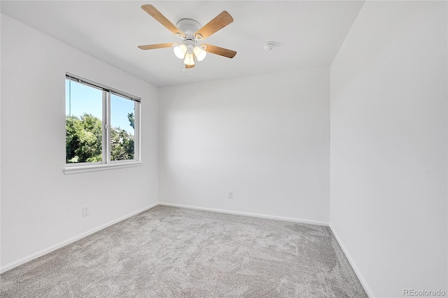 carpeted empty room featuring baseboards and ceiling fan