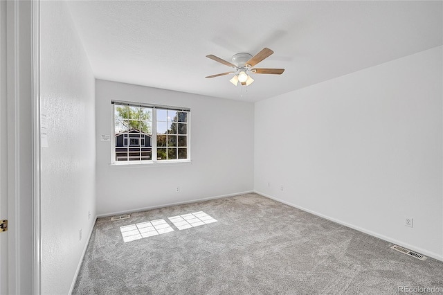 carpeted empty room with a ceiling fan and baseboards
