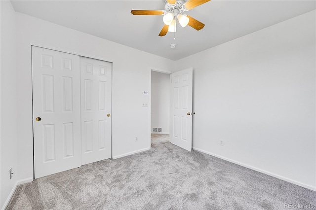 unfurnished bedroom featuring carpet, baseboards, a closet, and a ceiling fan