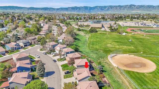 aerial view of property and surrounding area featuring nearby suburban area and mountains