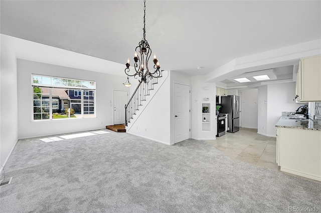 unfurnished dining area featuring baseboards, stairway, a chandelier, and light carpet