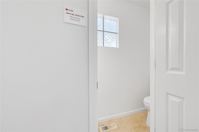 bathroom featuring toilet and baseboards