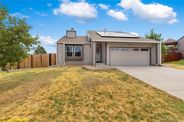 ranch-style house featuring a garage, a front lawn, and solar panels