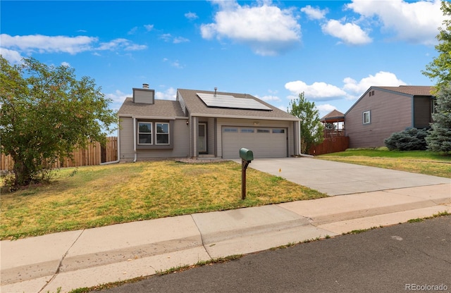 view of front of house featuring solar panels, a garage, and a front lawn