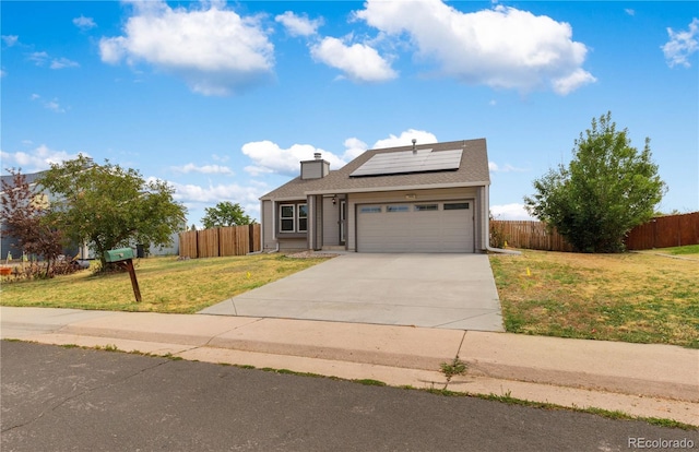 view of front of home with solar panels, a garage, and a front lawn