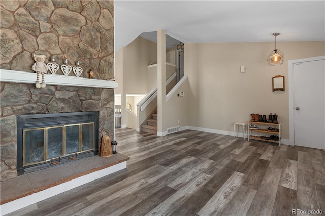 unfurnished living room with a fireplace, lofted ceiling, and hardwood / wood-style floors