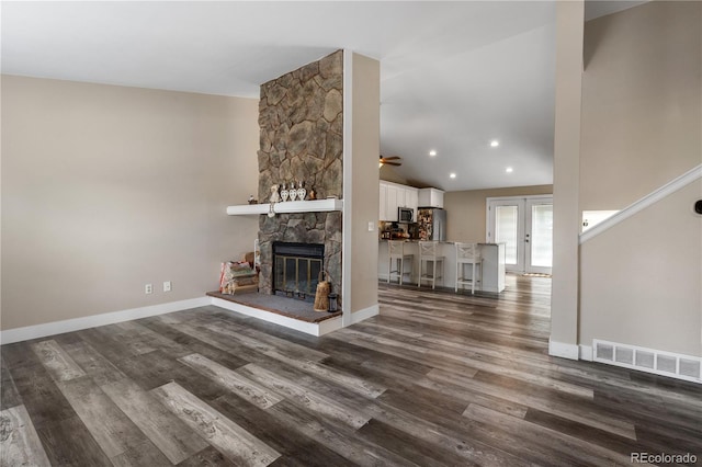 unfurnished living room with ceiling fan, a fireplace, hardwood / wood-style flooring, and vaulted ceiling