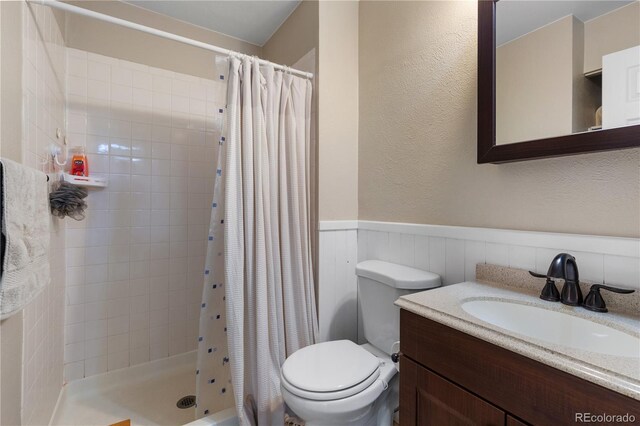 bathroom featuring vanity, curtained shower, and toilet