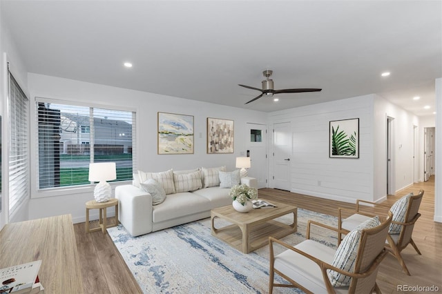 living area with light wood-type flooring, ceiling fan, recessed lighting, and baseboards