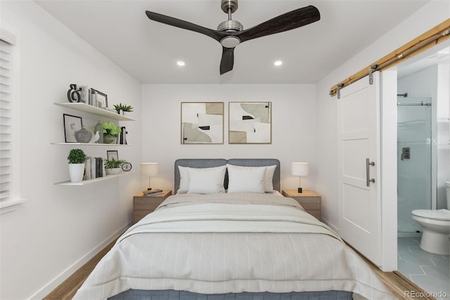 bedroom with a barn door, recessed lighting, ensuite bathroom, and a ceiling fan