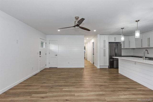 kitchen with fridge, recessed lighting, ceiling fan, a sink, and light countertops