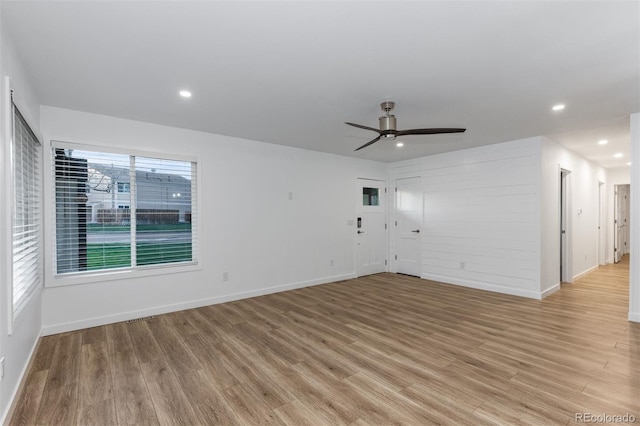 unfurnished living room featuring baseboards, light wood finished floors, ceiling fan, and recessed lighting