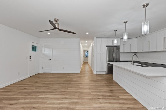kitchen with freestanding refrigerator, recessed lighting, a ceiling fan, a sink, and light wood-type flooring