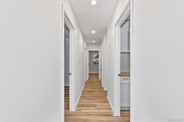 hallway with light wood-style flooring, recessed lighting, and baseboards