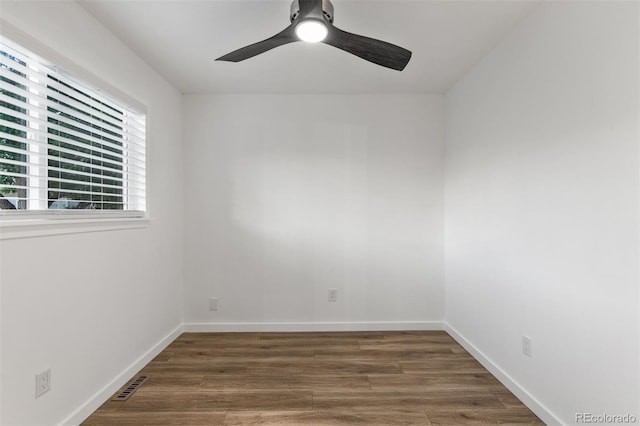 spare room featuring a ceiling fan, wood finished floors, and baseboards