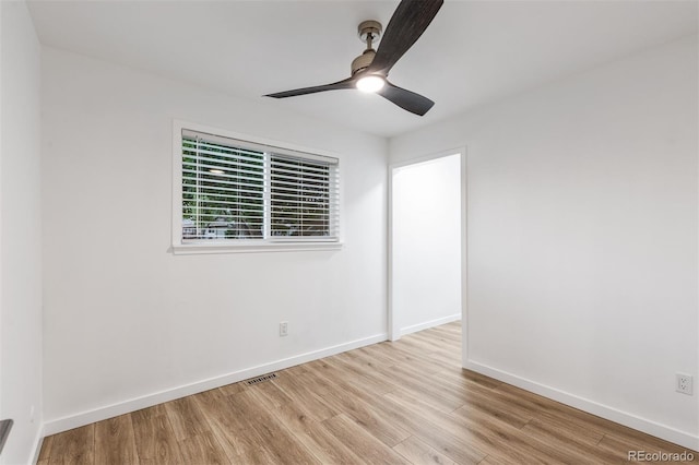spare room with wood finished floors, baseboards, and a ceiling fan