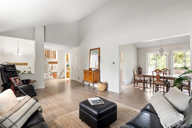 10572 E Orchard Pl, Englewood, CO 80111 - living room with healthy amount of natural light, high vaulted ceiling, stairs, light wood-style floors, and baseboards