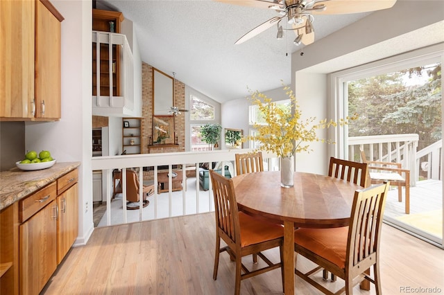 10572 E Orchard Pl, Englewood, CO 80111 - dining space with ceiling fan, light wood-style flooring, a textured ceiling, and high vaulted ceiling