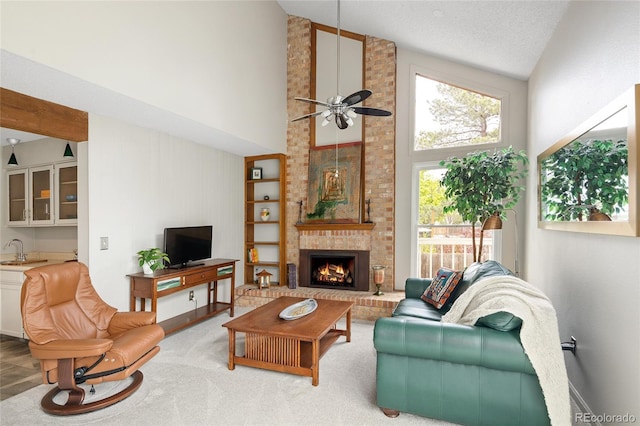 10572 E Orchard Pl, Englewood, CO 80111 - carpeted living room featuring high vaulted ceiling, a sink, ceiling fan, and a fireplace