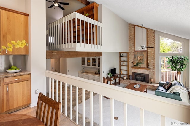 10572 E Orchard Pl, Englewood, CO 80111 - living area with a ceiling fan, light wood-type flooring, a fireplace, a textured ceiling, and high vaulted ceiling