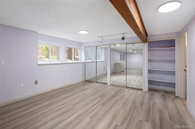 10572 E Orchard Pl, Englewood, CO 80111 - unfurnished bedroom with wood finished floors, multiple closets, and a textured ceiling