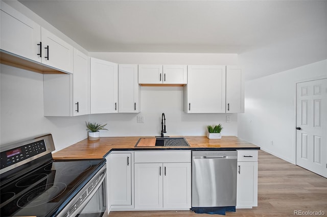 1607 Shasta Dr, Colorado Springs, CO 80910 - kitchen with stainless steel appliances, a sink, wood counters, and white cabinets