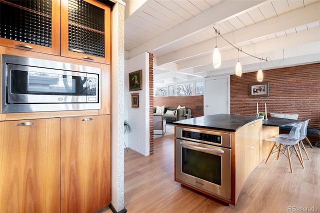 kitchen with stainless steel appliances, decorative light fixtures, brick wall, beam ceiling, and light hardwood / wood-style floors