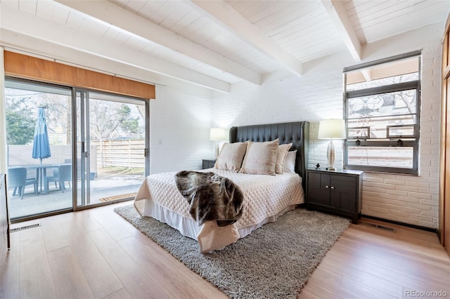 bedroom with brick wall, access to exterior, beam ceiling, and light hardwood / wood-style flooring