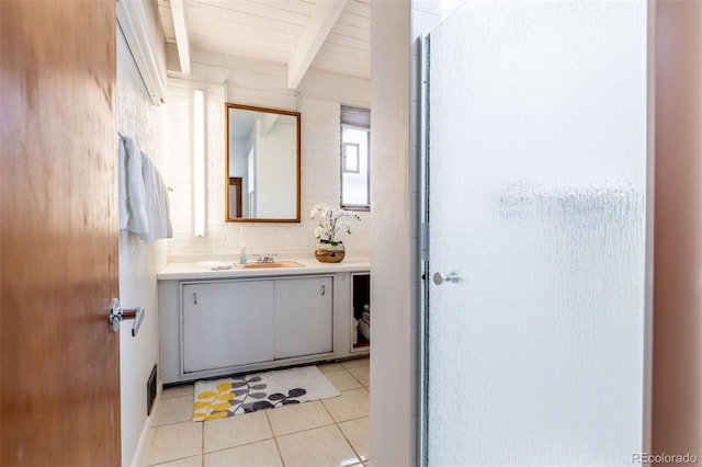 bathroom featuring beamed ceiling, tile patterned floors, and vanity