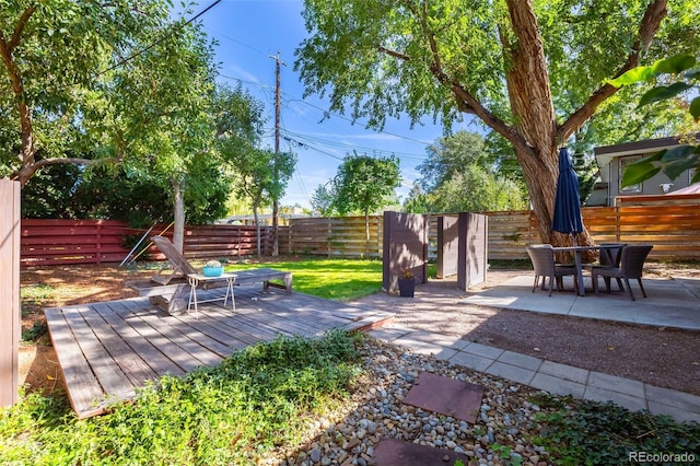 view of yard with a wooden deck and a patio