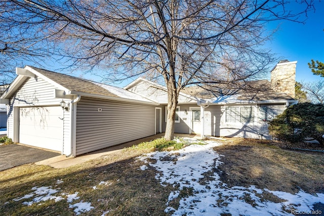 view of snowy exterior featuring a garage