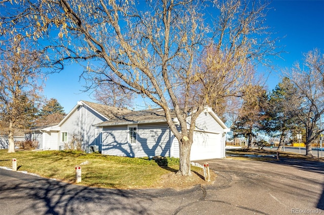 view of side of home featuring a lawn and a garage